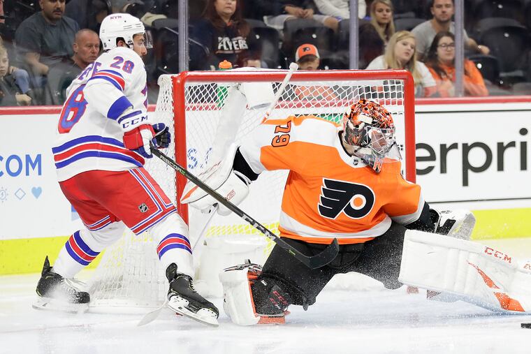 “I added some muscle, added some durability,” said Carter Hart, making a save against the Rangers' Phillip Di Giuseppe in a preseason game. “I feel really healthy in the net, really strong.”