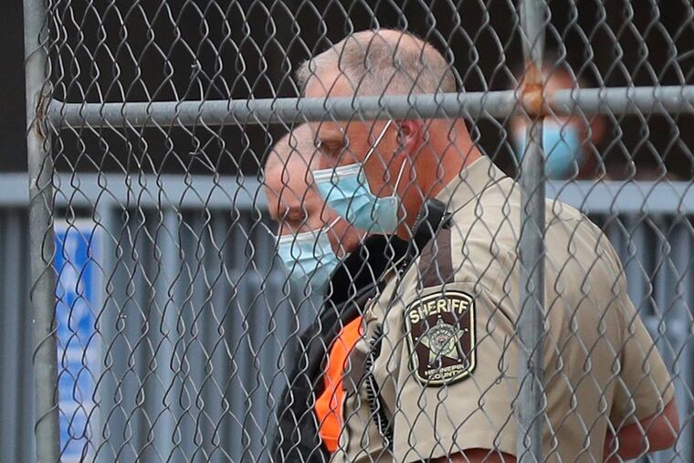Fired Minneapolis police officer Derek Chauvin was escorted from from the rear of the Family Justice Center by a law enforcement officer after a motion hearing Sept. 11 in Minneapolis.
