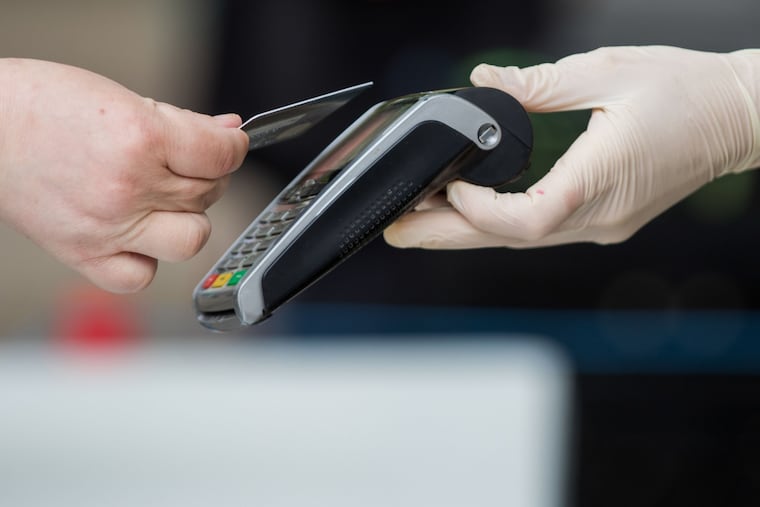 A customer uses a bank card to make a contactless payment on a market stall in Norwich, U.K., in 2020.