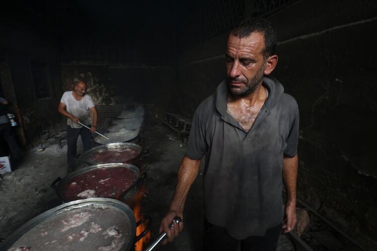Palestinians cook food for people displaced in the ongoing Israeli bombardment of the Gaza Strip in Rafah on Saturday.
