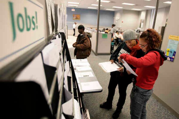Job seekers examine listings at a Providence, R.I., employment center. Joblessness has hampered consumer spending.