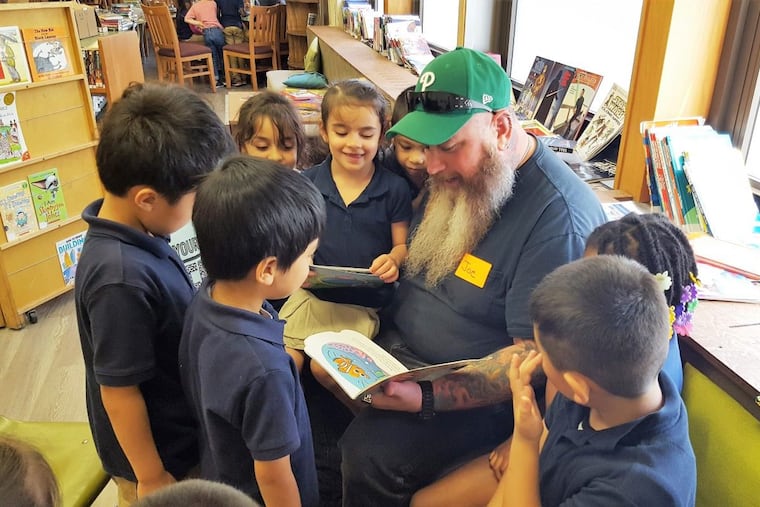 Joe Chirik, RevZilla customer service team leader, reads to Mary Kaplan’s kindergarten class at John H. Taggart Elementary School in South Philly. RevZilla is in its second year as a corporate partner of Taggart.