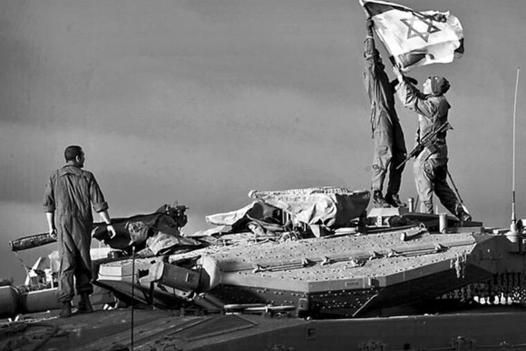 Israeli soldiers hang a flag atop a tank near the Gaza Strip. Israel's limited definition of goals offers Hamas good survival odds, even if the onslaught leaves it badly weakened.