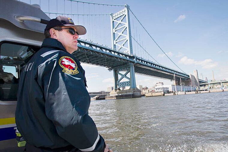 Marine Unit Officer Joseph Curley passes under the Ben Franklin Bridge during a routine patrol along the Delaware River. (Alejandro A. Alvarez/Staff)