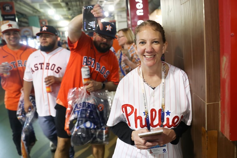 Philadelphia Inquirer reporter Kristen Graham wears her Phillies jersey in the concourse while Astros fans jokingly put their thumbs down at Minute Maid Park in Houston.