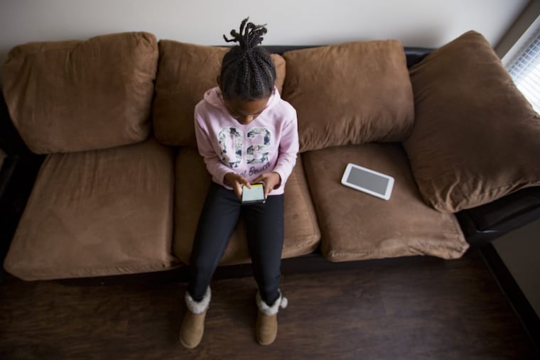 Tayana Knight on her cell phone while at her home. Most of her time is spent looking at devices, except for when she is at Camp Jamison, which has a strict no screen policy.