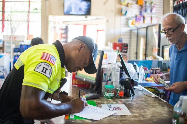 Officer Kerry Dunbar II, 28, signs a police log in a Cedar Food Market on Arctic Avenue in Atlantic City.