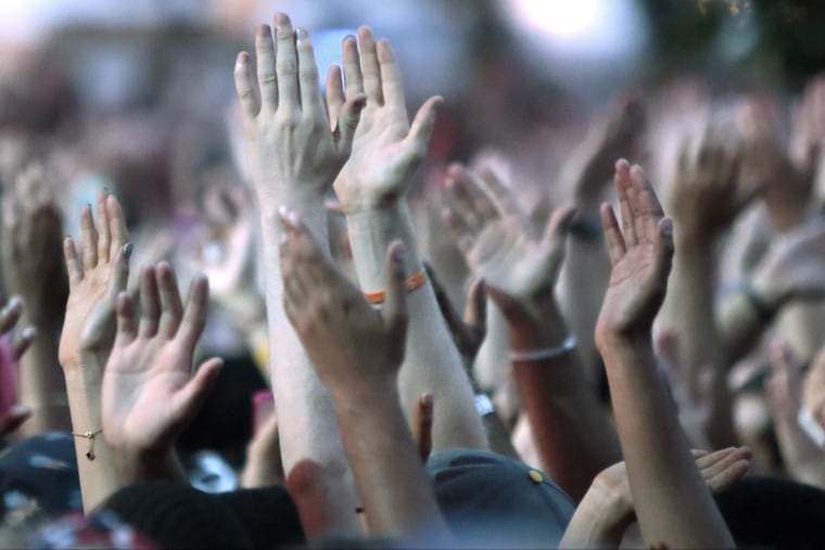 Fans cheer as J. Cole takes to the Liberty stage to perform during the Budweiser Made in America Festival, on the Ben Franklin Parkway, in Philadelphia on August 30, 2014.