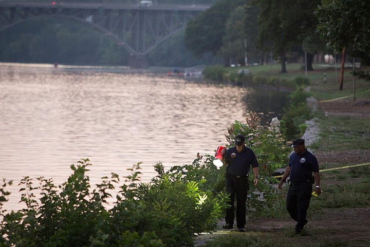 Philadelphia police investigate along the Schuylkill River early Wednesday morning near the reviewing stand by the Jack Kelly statue where two bodies were pulled from the river. ( ALEJANDRO A. ALVAREZ / STAFF PHOTOGRAPHER )