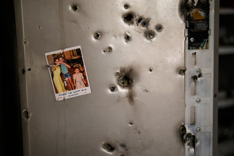 A photo hangs on a refrigerator next to bullet holes in a house at Kibbutz Kissufim in southern Israel. The kibbutz was overrun by Hamas militants from the nearby Gaza Strip on Oct. 7, 2023, when they killed at least 1,200 Israelis and took 250 hostages.