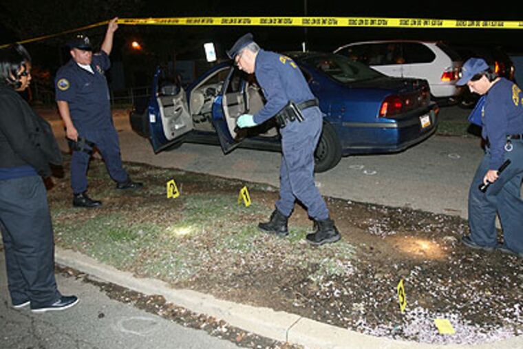 Three teenagers were shot Thursday night while sitting in a dark-colored car outside of the Cobbs Creek Recreation Center on South 63rd Street near Spruce Street. Here, members of the Crime Scene Unit search for evidence. (Charles Fox / Staff Photographer)
