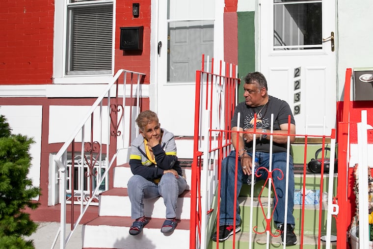 Iris Rodríguez, left, and Antonio Bonaparte sit outside of Bonaparte’s home in the Norris Square neighborhood of North Philadelphia on Wednesday. Philadelphia released its first property reassessments in three years. Many homeowners are seeing a significant increase.