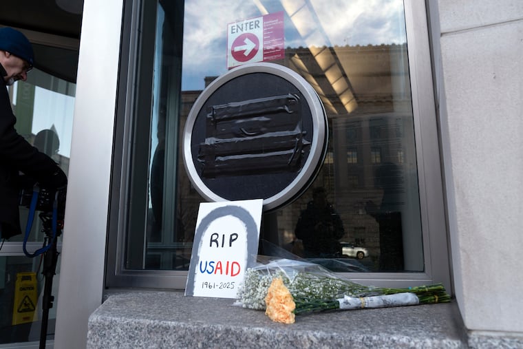 Flowers and a sign are placed outside the headquarters of the U.S. Agency for International Development, or USAID, in Washington in early February.