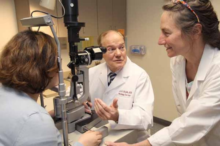 Jerry, center, and Carol, right, Shields, the husband and wife team of world renowned eye cancer specialists at Wills Eye Institute, confer while examining a patient. ( CHARLES FOX / Staff Photographer )