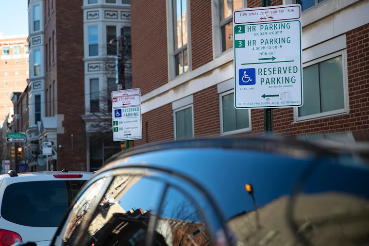 Signs designating parking reserved for disabled drivers mark off a space on the corner of Spruce and Ninth Streets in Philadelphia. The Philadelphia Parking Authority has relocated dozens of disabled parking spots in the process of replacing the parking kiosks in Center City.