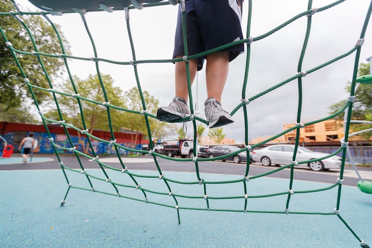 A child climbs the netting that is part of the playgound equipment at the Fishtown Recreation Center Philadelphia.