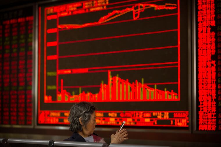 A Chinese investor uses her smartphone as she monitors stock prices at a brokerage house in Beijing, Friday, May 31, 2019. Asian shares were mixed Friday as trade worries continued after President Donald Trump announced additional tariffs on imports from Mexico. (AP Photo/Mark Schiefelbein)