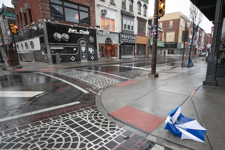 An abandoned umbrella sits across from Jim's Steaks at Fourth and South Streets. The restaurant has embraced the DoorDash delivery service to get orders.