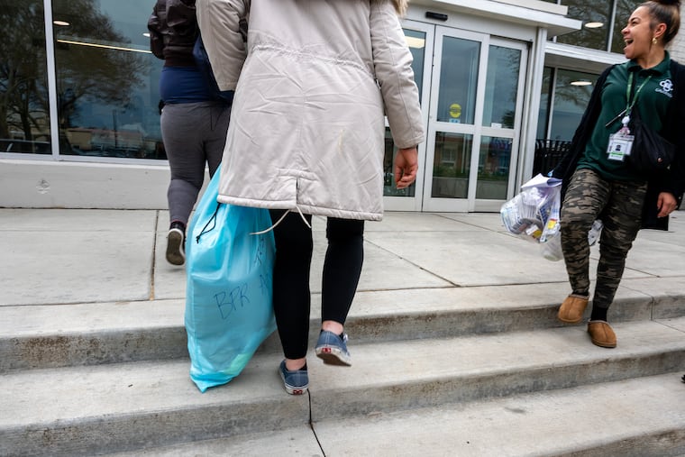 Francesca Colon (right), a recovery support professional with Gaudenzia, brings people in recovery to the main entry of Meeting House at Riverview Wellness Village, a city-owned drug recovery home in Northeast Philadelphia, on Tuesday, Nov. 25, 2025.