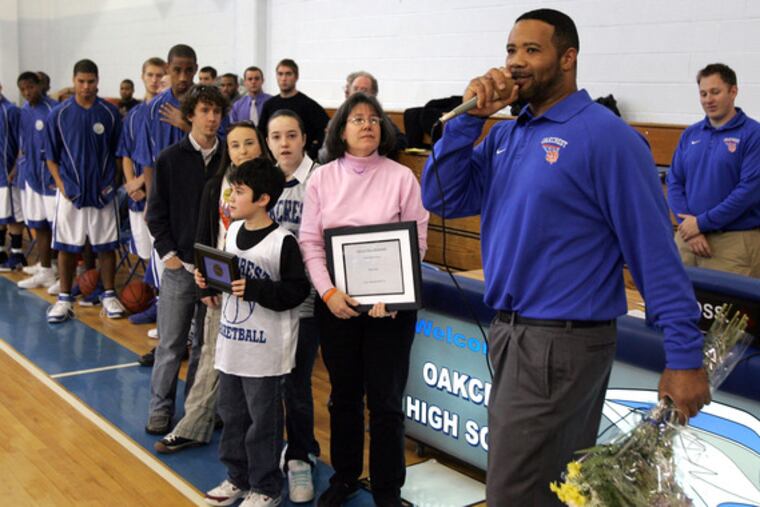 Oakcrest coach Frank Brown calls the family of the late Dave Lewis to the court. Lewis' widow, Beth, and son, David, hold plaques. They are joined by daughters Rebecca and Emily, and Rebecca's fiance, Colin Hasson.