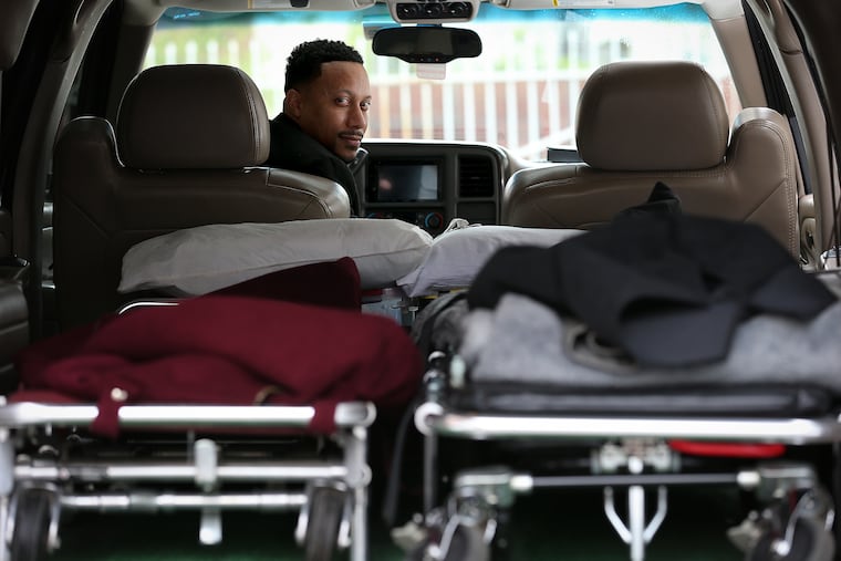 Preston Griffin, who runs First Class Mortuary Transport, inside his vehicle after delivering a body to the Alfonso Cannon Funeral Chapels in Philadelphia.
