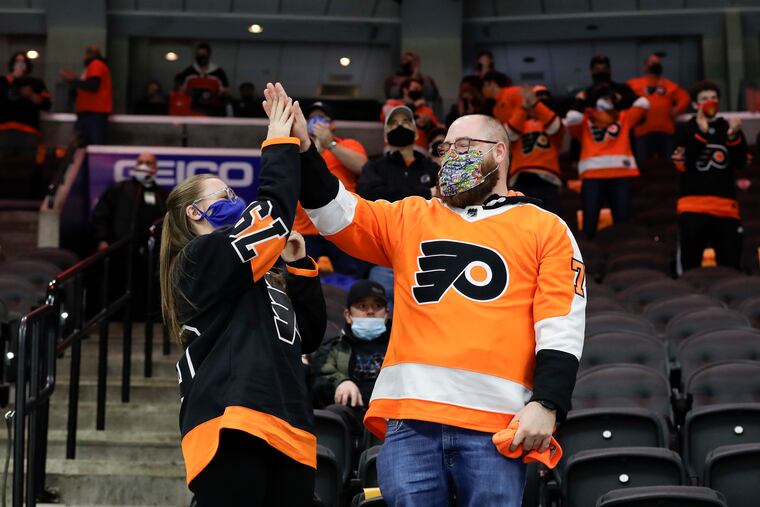 Flyers fans celebrate a first period goal against the Washington Capitals on Sunday, the first time fans were allowed to watch a game in person at the Wells Fargo Center. Under new relaxed COVID-19 restrictions, the Flyers and Sixers will allow 3,100 fans to attend games at the Wells Fargo Center.