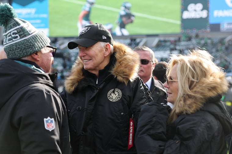 President Joe Biden (center) and Jill Biden meet with Eagles owner Jeffrey Lurie before the team's game against the Las Vegas Raiders on Sunday, Dec. 14, 2025, in Philadelphia.