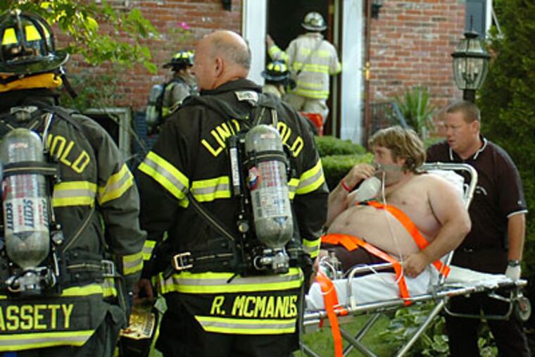 Firefighters carried Liam Doherty away from his son's burned-out house in Laurel Springs. (Clem Murray/Staff Photographer)