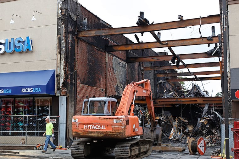 Workers were busy clearing away the charred debris from the burned out shell of the Payless Store on 69th street in Upper Darby Thursday July 9, 2015. ( Michael Bryant / Staff Photographer )