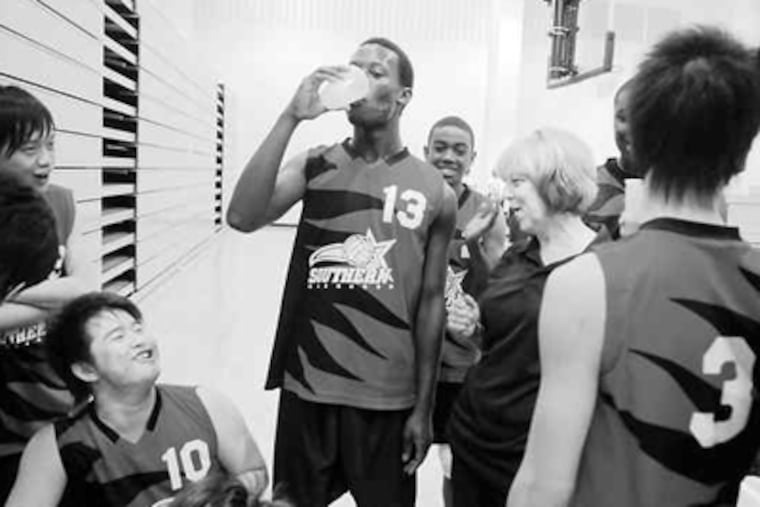 Volleyball coach Patricia Buchanan (center right) celebrates with the South Philadelphia High School Rams, including Jia Hua Mai (lower left), after their championship-winning game on Tuesday. (Sarah J. Glover / Staff Photographer)