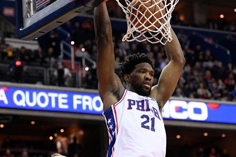 Philadelphia 76ers center Joel Embiid (21) scores in front of Washington Wizards forward Sam Dekker (8) during the first half of an NBA basketball game, Wednesday, Jan. 9, 2019, in Washington. (AP Photo/Nick Wass)