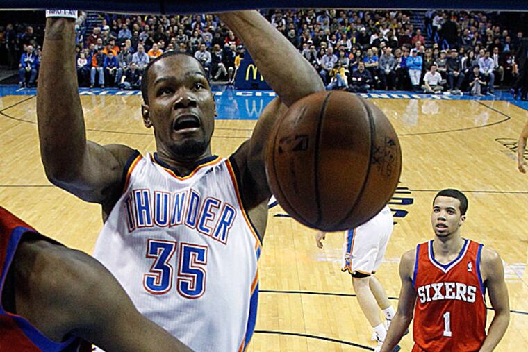 Thunder forward Kevin Durant and 76ers guard Michael Carter-Williams. (Sue Ogrocki/AP)