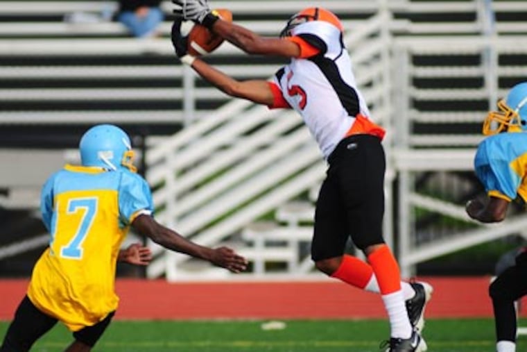<b>Del-Val Charter 14, Communications Tech 0</b> Del-Val Charter's defensive back Brad Wilson, center, tries for an
interception against Communications Tech's Gameel Strange, left, during second half action on Thursday afternoon. (Jason Melcher /
Staff Photographer)