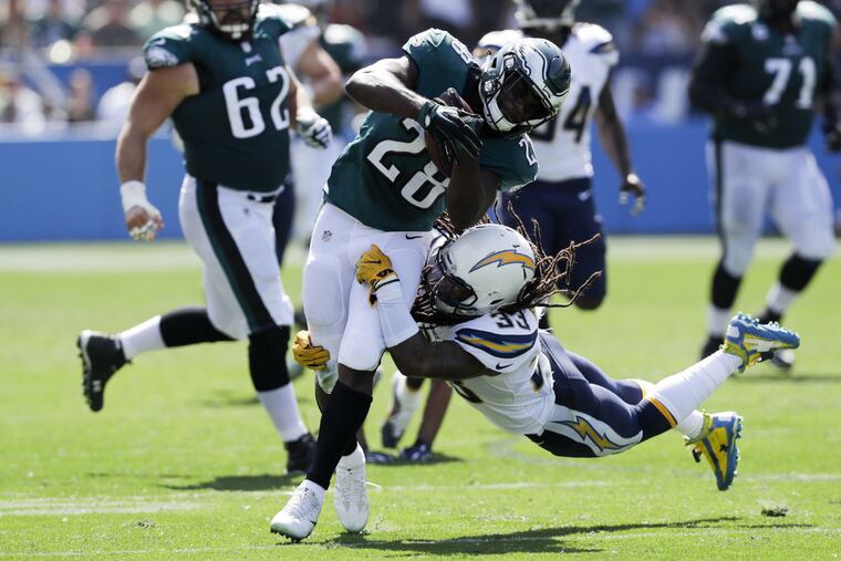 Eagles running back Wendell Smallwood runs with the football against Los Angeles Chargers free safety Tre Boston during the first-quarter on Sunday, October 1, 2017 in Carson, CA. YONG KIM / Staff Photographer
