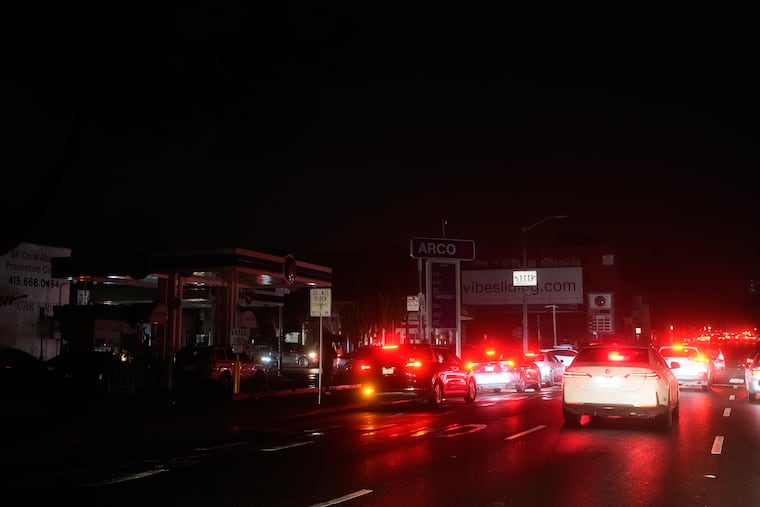 Cars wait at an intersection with no working traffic lights from power outages, in San Francisco, Saturday, Dec. 20, 2025.