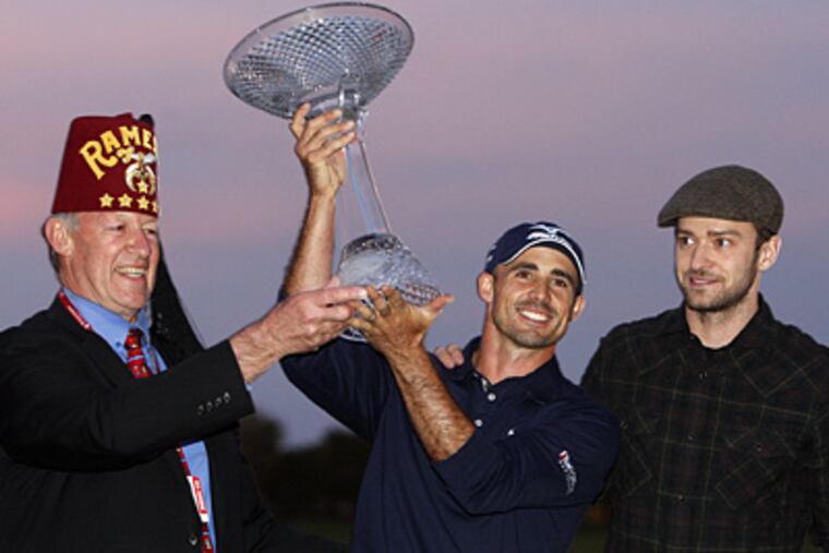 George Mitchell, left, from the Shriners, and Justin Timberlake present Jonathan Byrd with his trophy. (AP Photo/Isaac Brekken)