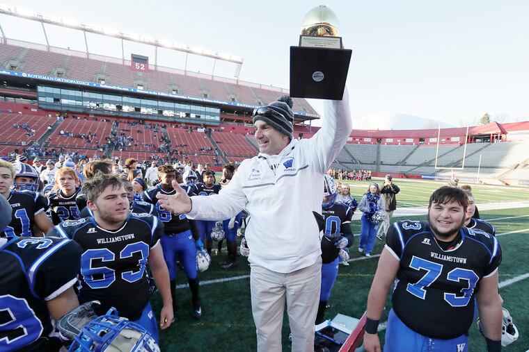 Williamstown coach Frank Fucetola holds up the Group 5 region trophy after the Braves beat Cherokee on Saturday.