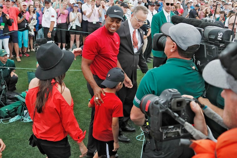 Tiger Woods smiles as he and his son, Charlie, walk off the course on Sunday at Augusta National.