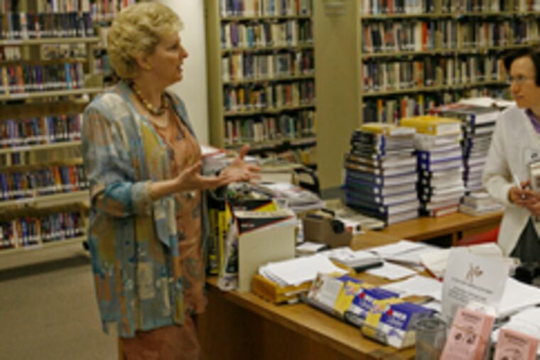 Kathy Arnold-Yerger (left), executive director of the Montgomery County-Norristown Public Library, talks with reference librarian Mary Ann Kurcsik. The library wants to move and remodel the reference area with its share of Keystone grant money. A Senate bill would divert nearly half of the Keystone budget to the Hazardous Sites Cleanup Fund.