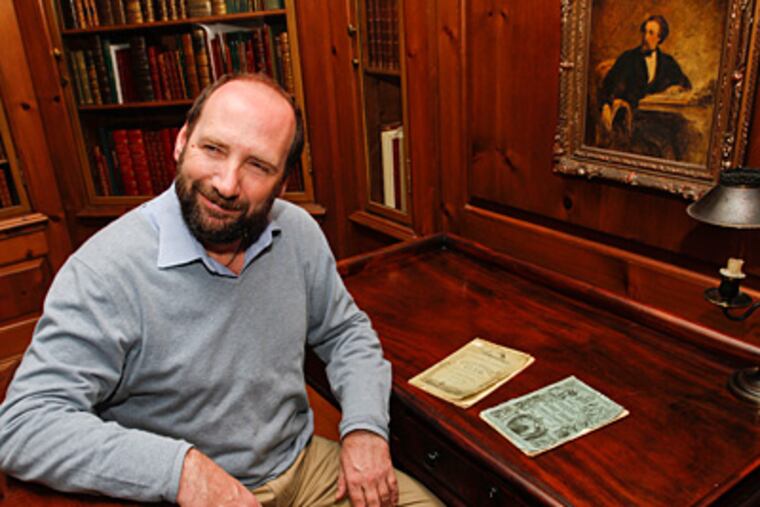 Gerald Dickens sits at his great-great-grandfather's desk at the Free Library, where two exhibits mark next year's bicentennial of Charles Dickens' birth. (Michael S. Wirtz / Staff Photographer)