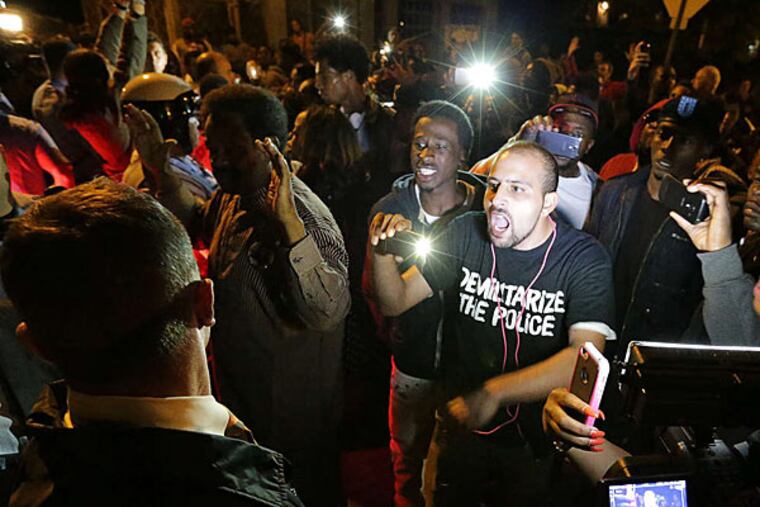 Demonstrators confront police last month in Ferguson.