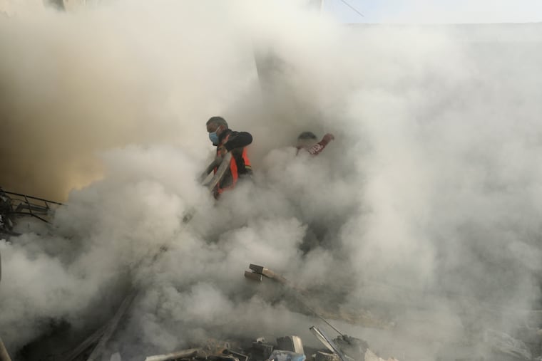 Palestinian firefighters extinguish fire caused by an Israeli airstrike in Khan Younis refugee camp, southern Gaza Strip on Tuesday.