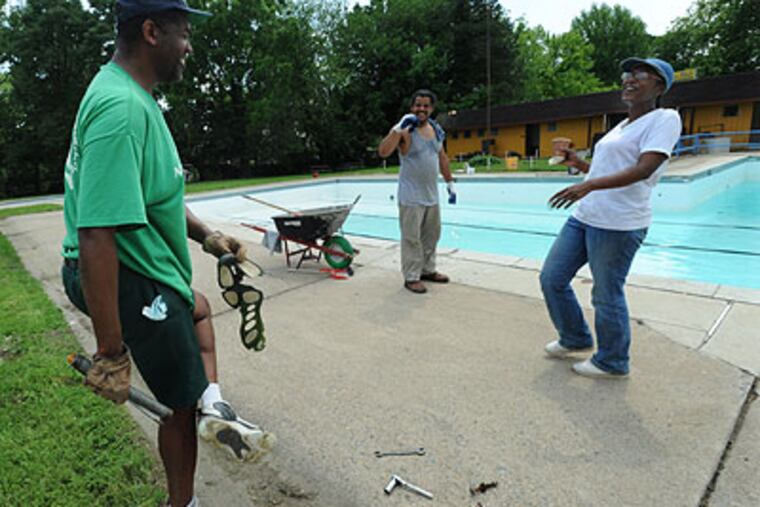 At the Nile Swim Club in Lansdowne, volunteers work to get it ready for this week's opening. Here, Clifford Brock, who's been repairing a bench, makes Peter and Chenelle Cooper laugh by showing them the sole that's come off his sneaker while he was working. (April Saul / Staff Photographer)