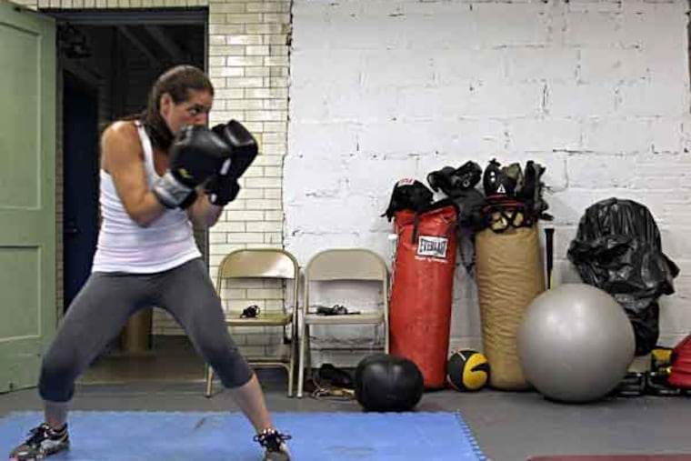 Dianna Cute of Roxborough warms-up before sparing, as hitting bags sit on the floor inside the boxing gym at the Kendrick Recreation Center in the Roxborough section of Philadelphia on Monday, July 22, 2013. ( Yong Kim / Staff Photographer )