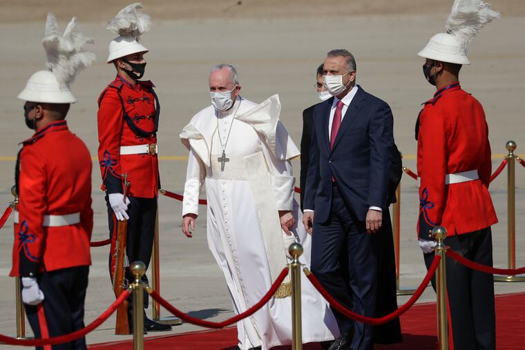 Pope Francis is flanked by Iraqi Prime Minister Mustafa al-Kadhimi upon his arrival at Baghdad’s international airport, Iraq, Friday, March 5, 2021. Pope Francis heads to Iraq on Friday to urge the country’s dwindling number of Christians to stay put and help rebuild the country after years of war and persecution, brushing aside the coronavirus pandemic and security concerns.