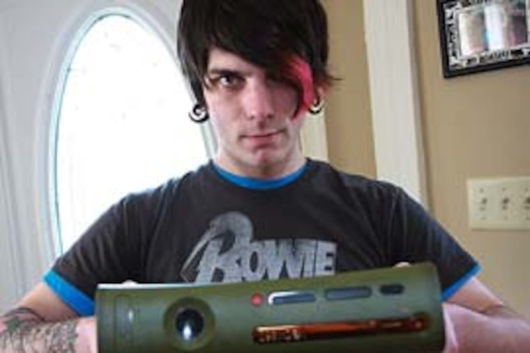 Jesse McPherson shows off his XBOX, which was returned to him after he posted photos of the alleged burglar on his website. (Mhari Scott / Daily News)