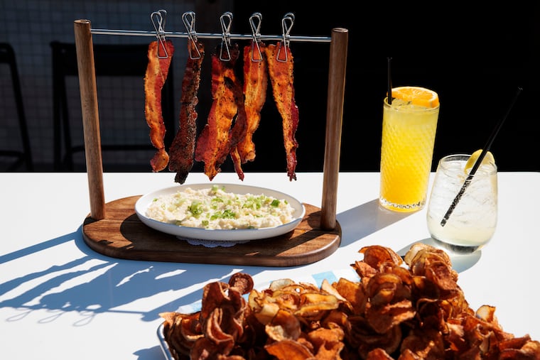 The Hanging Candied Bacon served over grits and Gully’s Blooming Potato at Gully's on Wednesday, June 17, 2026 in Avalon, NJ.