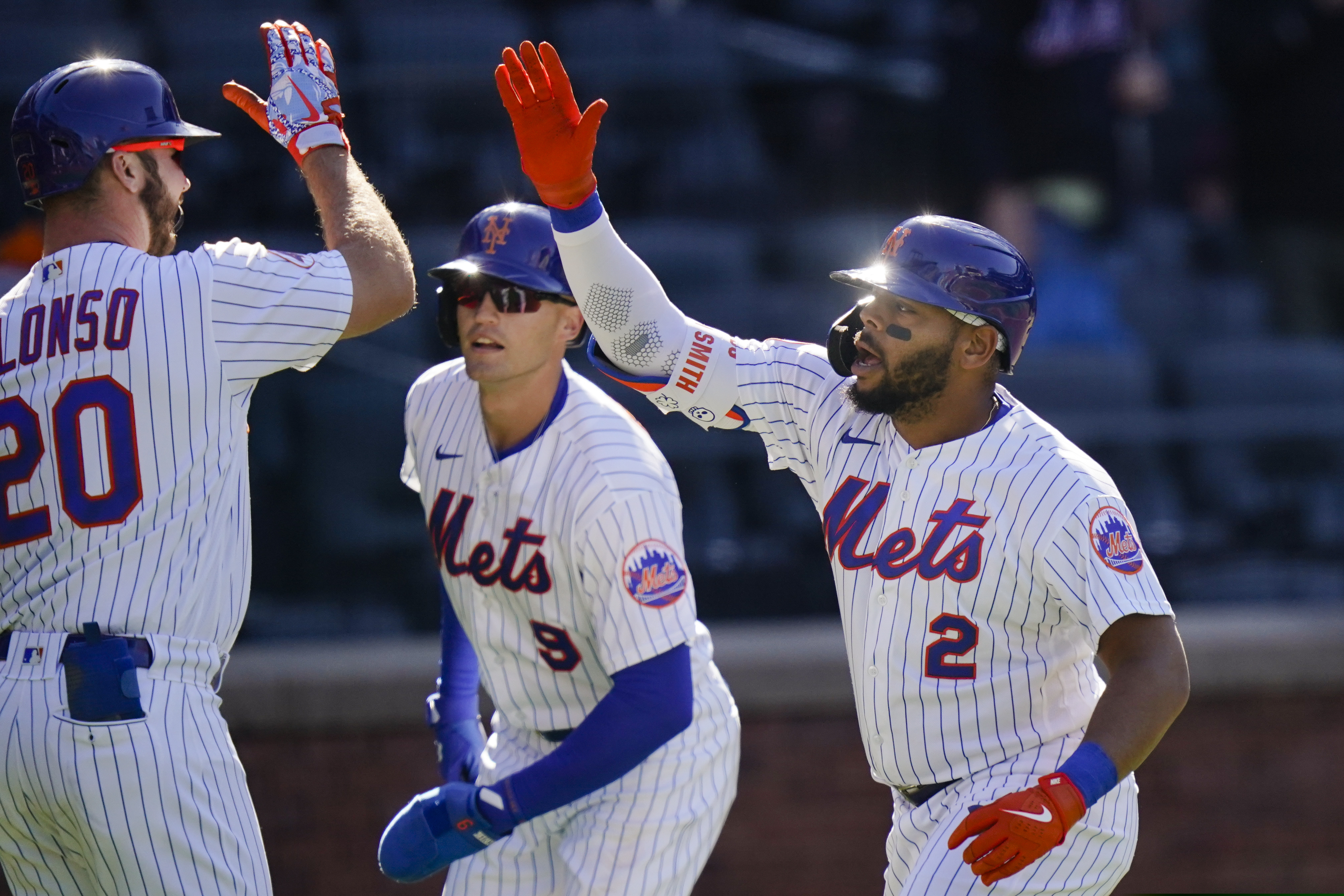 The Mets' Pete Alonso celebrates with Brandon Nimmo (9) and Dominic Smith after Smith hit a two-run home run during the first inning of Game 1.