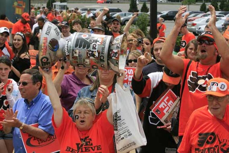 Dot Vadino,56 from South Philladelphia hoists a homemade Stanley Cup during the pep rally Friday at the Wachovia Center.