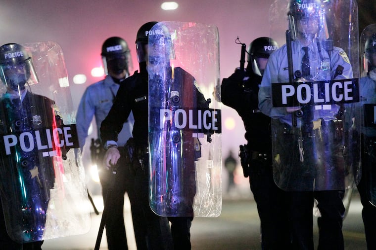 Philadelphia police marching down 52nd Street. Unrest spread through the neighborhood after Philadelphia police shot and killed Cobbs Creek resident Walter Wallace Jr. just hours earlier.